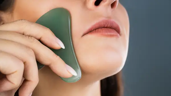 Woman using gua sha tool