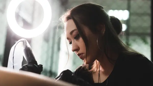 A professional artist inks her client