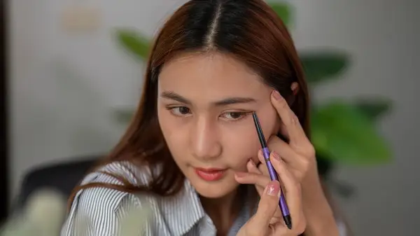 Woman applying eyeliner