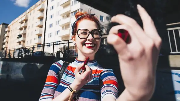 Woman applying red lipstick