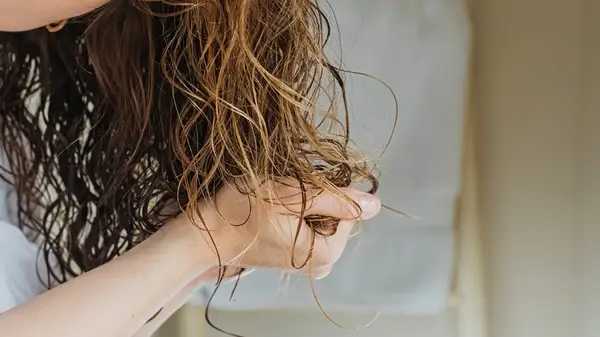 Woman applying product to her hair 