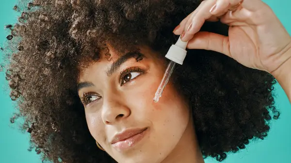 Woman applying retinol serum to face