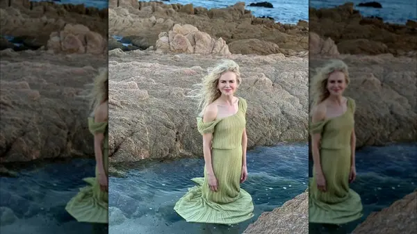 Nicole Kidman standing in knee-high water while smiling at the camera