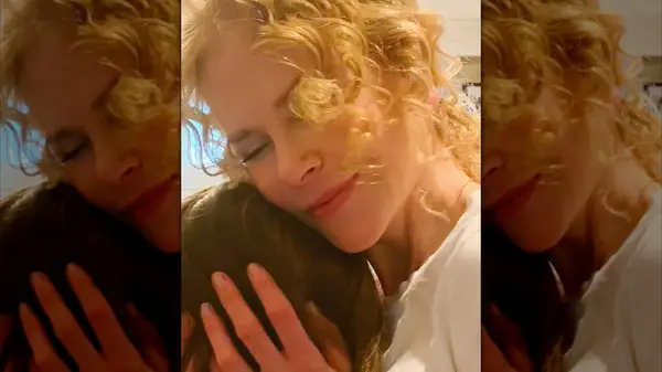 Close-up of Nicole Kidman with face-framing curls hugging her child