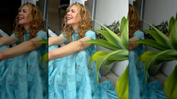 Nicole Kidman laughing while sitting next to a plant