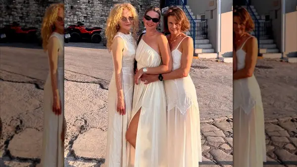 Nicole Kidman with curly, middle-parted hair posing with her sister and niece