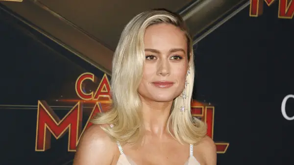 Brie Larson on the red carpet with platinum blonde hair and star earrings