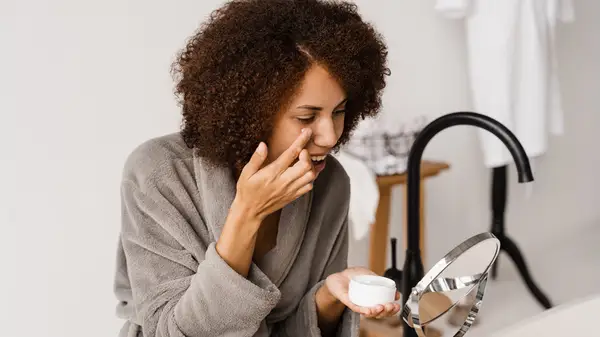 Woman putting on eye cream