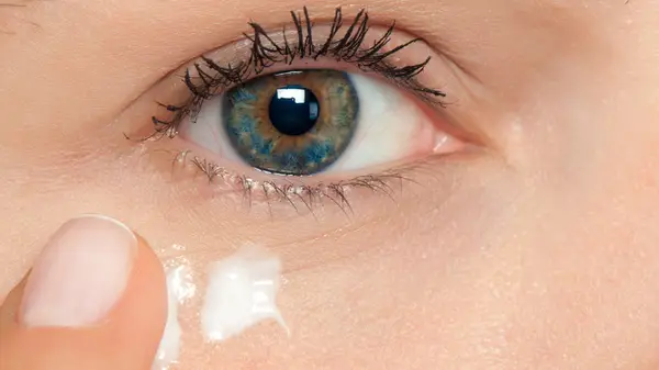 Woman putting on eye cream