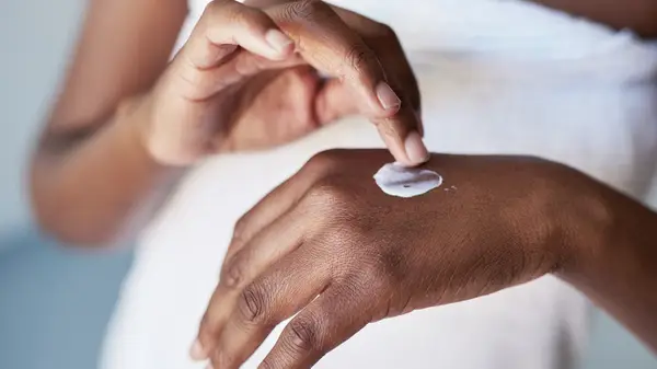 Woman applying moisturizer