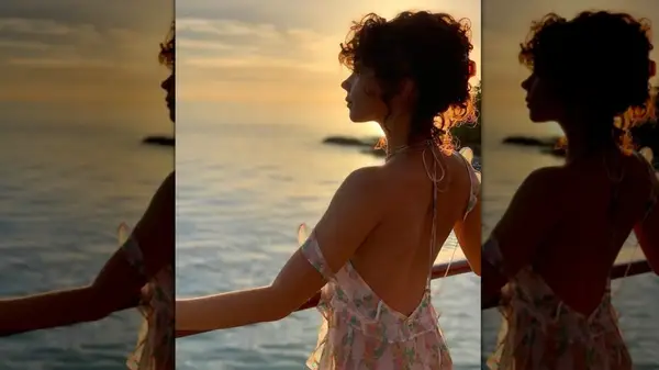 Sarah Hyland with clipped-up curly hair looking out at the ocean