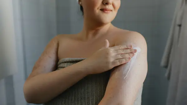 Applying moisturizer to arm