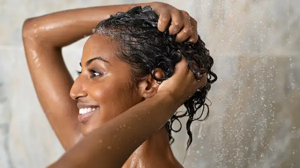 woman using shampoo in shower