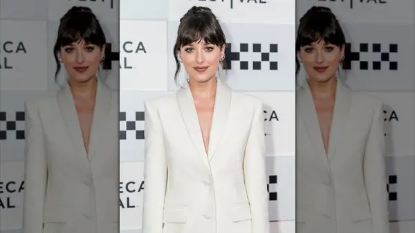 Dakota Johnson on the red carpet wearing a white suit