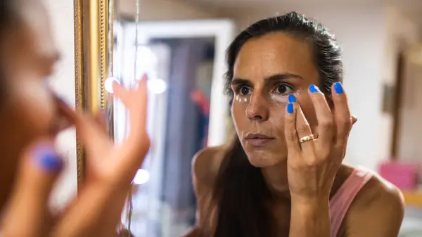 Woman applying concealer