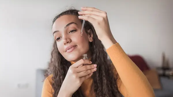 Woman applying serum to her face