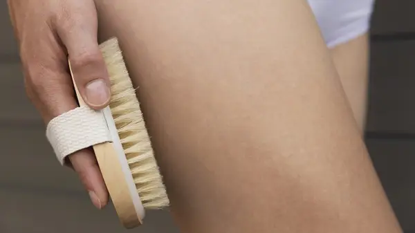 Woman dry brushing skin
