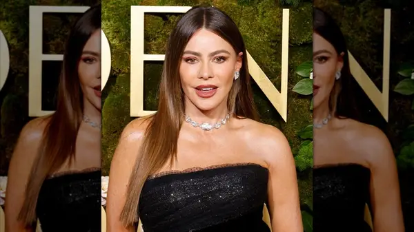 Sofia Vergara posing with full brows and reddish-orange lipstick