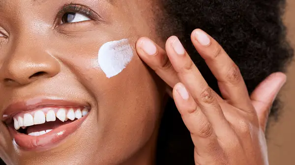 Woman applying moisturizer