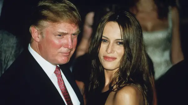 Melania Trump in a sleeveless dress and Donald Trump in a suit at an event