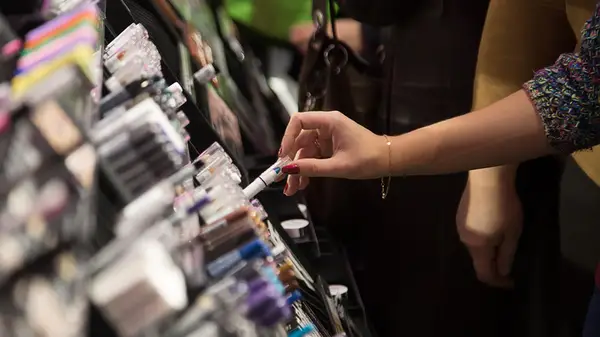 hand reaching to try eye makeup tester tube