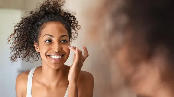 woman applies skincare product