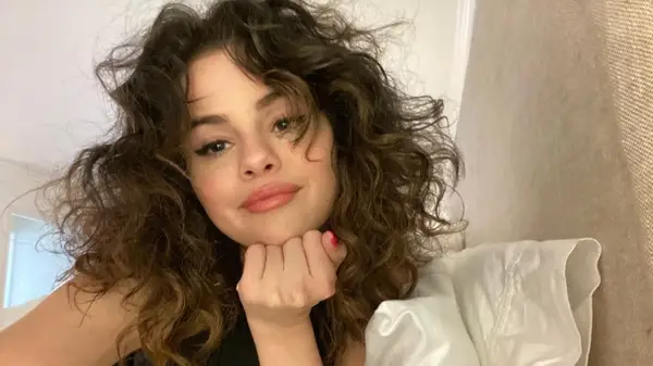 A selfie of Selena Gomez with shoulder-length, curly hair