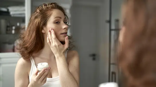 woman applying face cream
