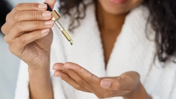 woman putting oil in hand