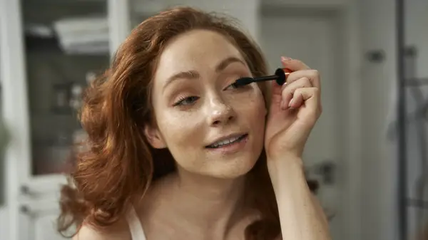 woman applying mascara