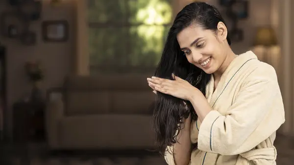 Woman applying oil to ends of hair