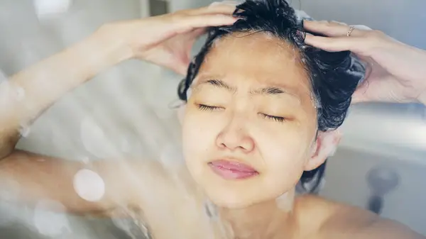 Woman washing hair in shower