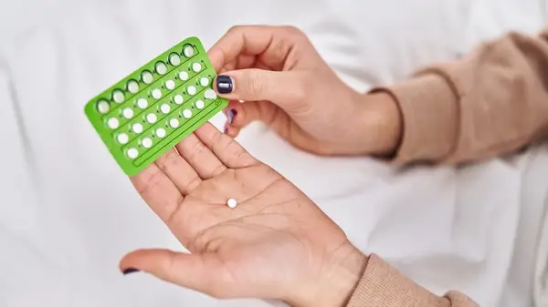 woman holding birth control pack 