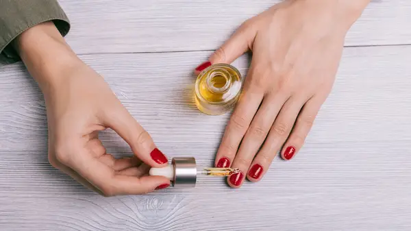 woman applying cuticle oil