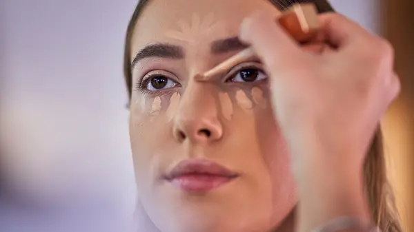 woman applying concealer