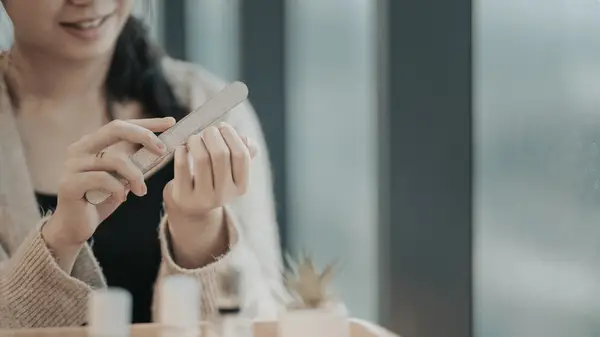 Woman filing nails at home