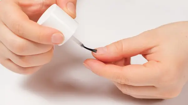 Top coat being applied to nails