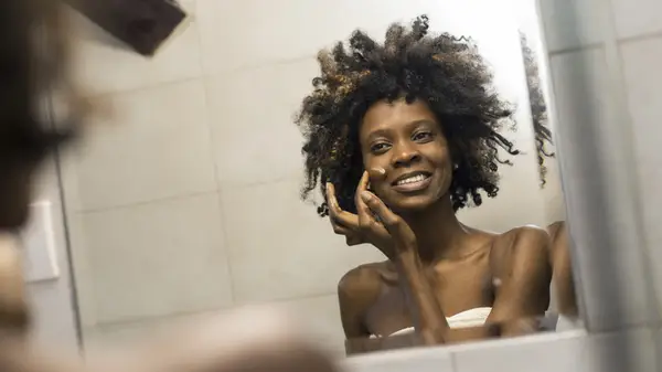 Woman applying moisturizer