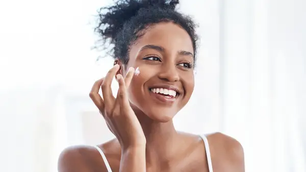 Woman putting lotion on face