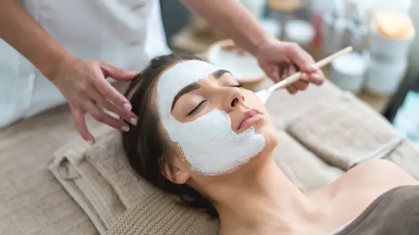 Applying a face mask to a woman
