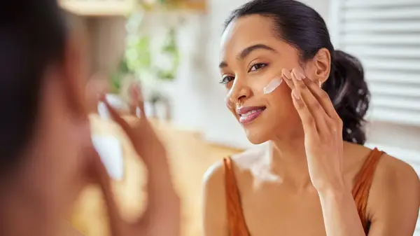 woman applying moisturizer