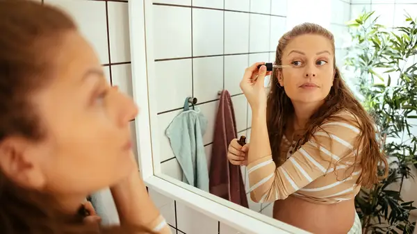Woman applying skincare around eyes