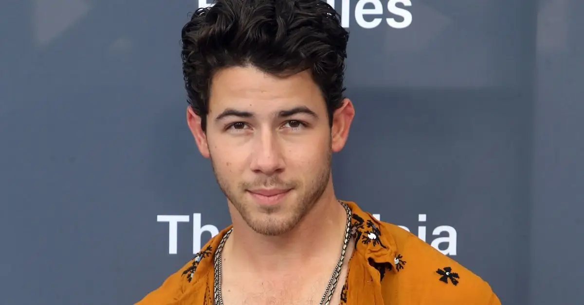 Nick Jonas sonriendo en la alfombra roja