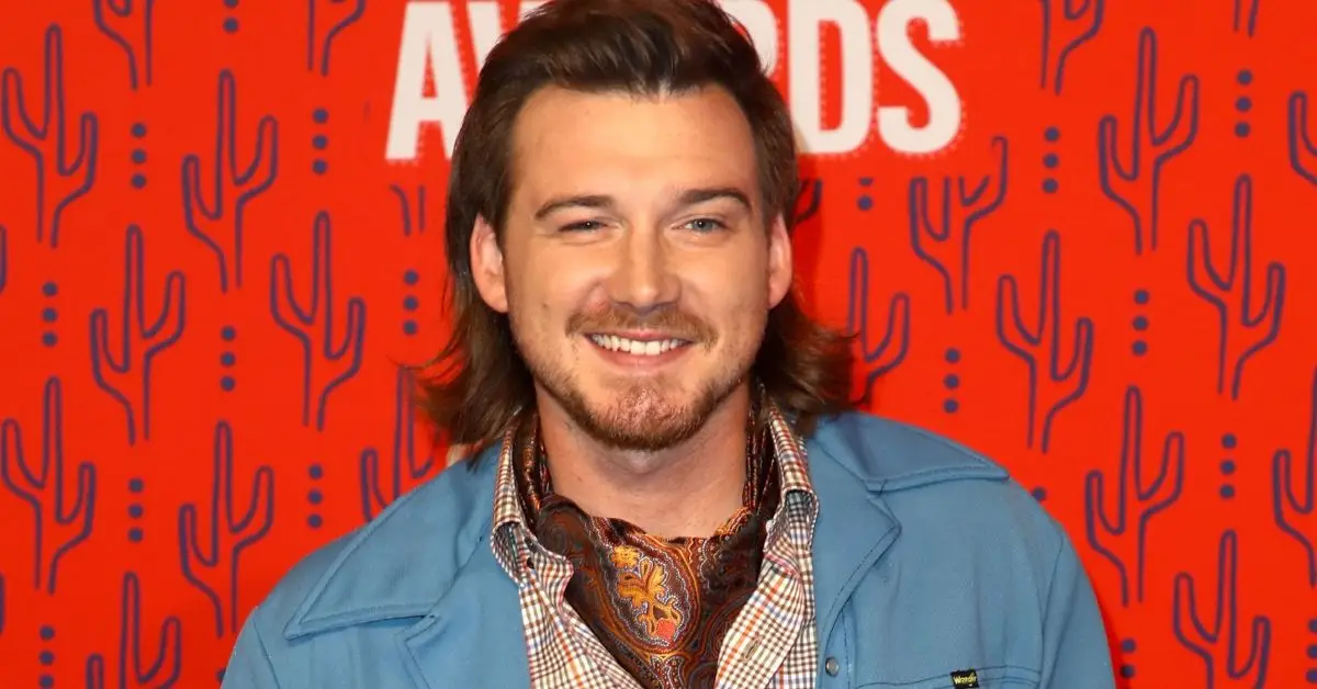 Morgan Wallen uśmiecha się na czerwonym tle