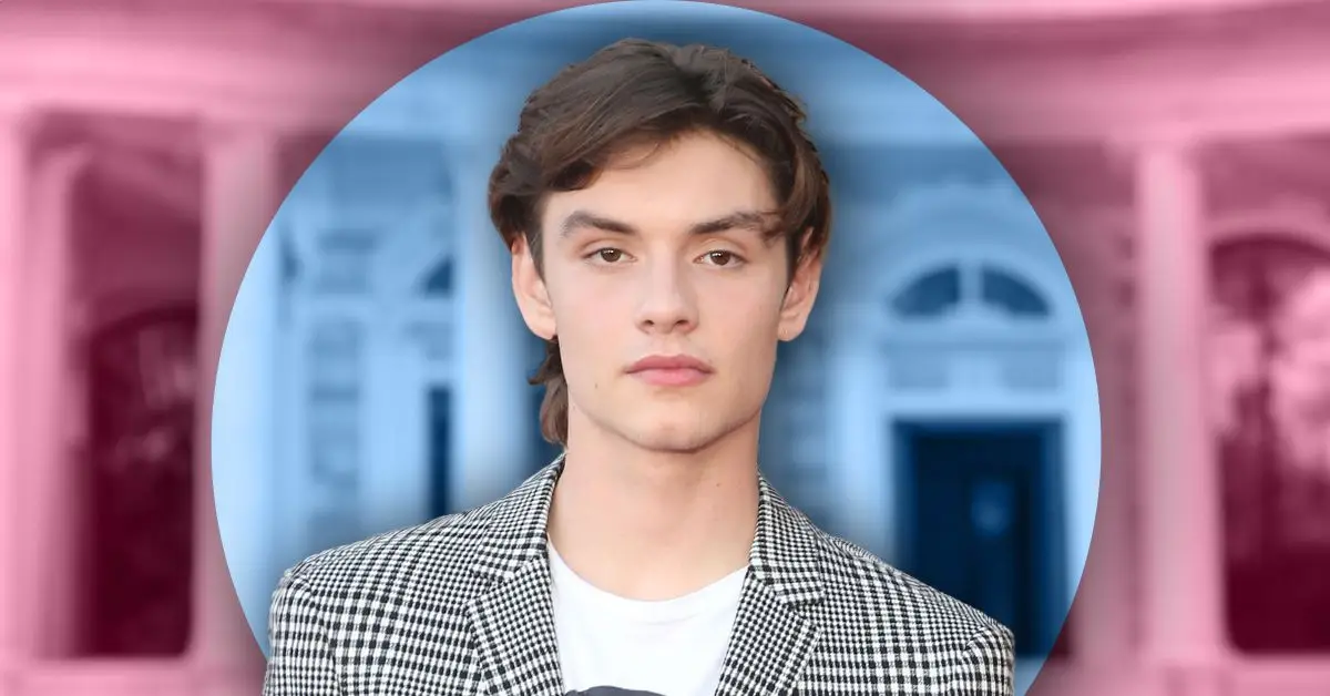 Skådespelaren Louis Partridge på röda mattan i snygg kostym som ser stilig ut