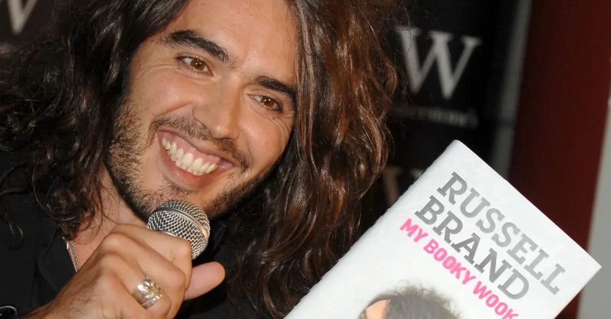 Russell Brand tient un micro lors d'un événement pour son livre