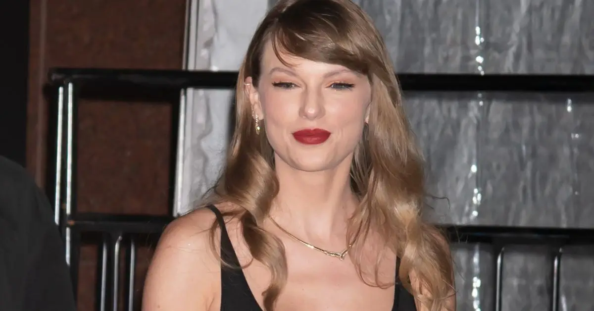 Taylor Swift com um sorriso no rosto em um evento