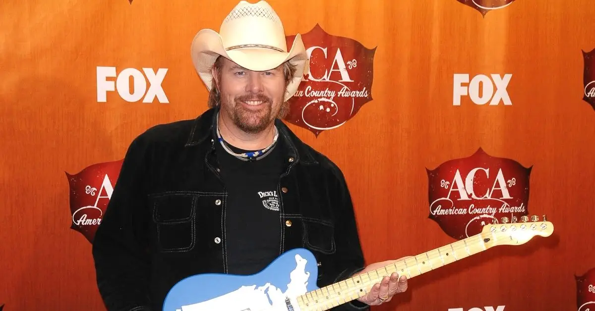 Toby Keith smiler og holder en guitar