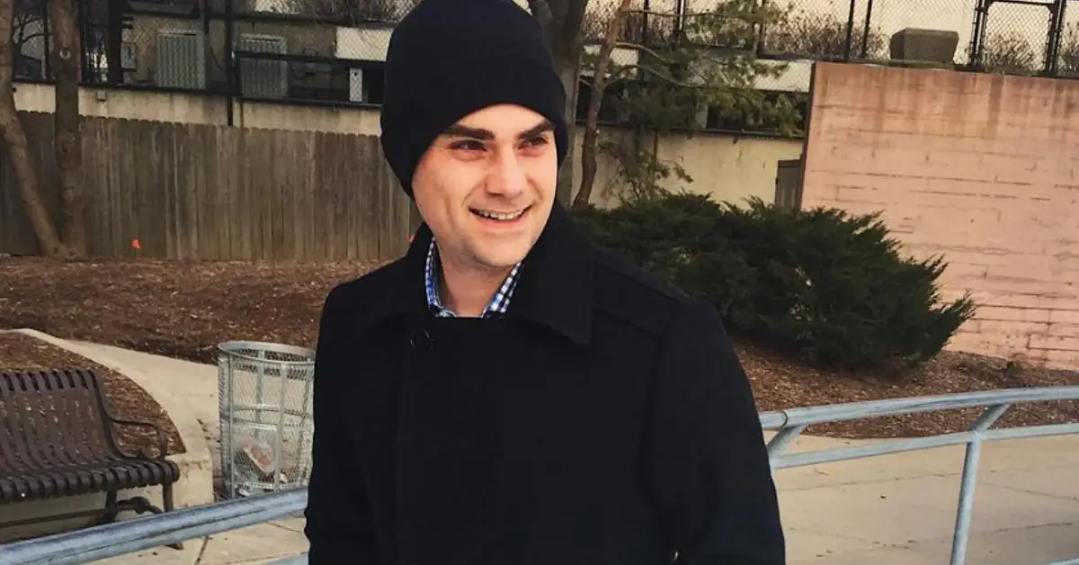 帽子とコートを着て外で微笑むベン・シャピロ