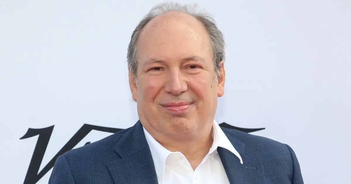 Hans Zimmer sorridente in giacca e cravatta sul tappeto rosso a un evento